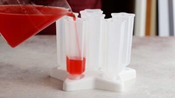 pouring a red liquid into a popsicle mold
