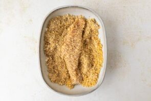 A chicken cutlet breaded in the breading bowl.