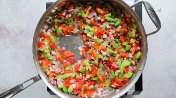 Pepper and onions sautéing in a skillet.