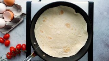 a tortilla laying in a skillet over a stove top burner