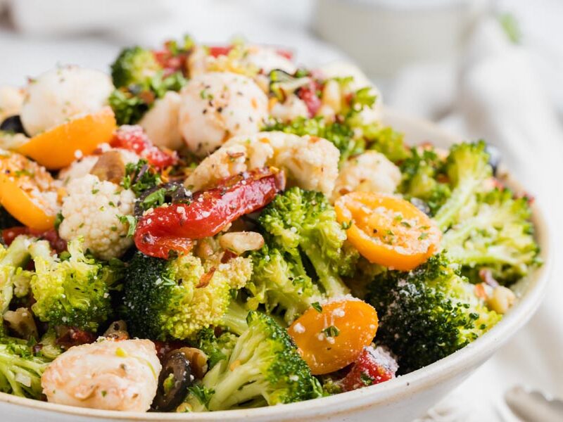 Broccoli and cauliflower salad with tomatoes, red peppers, olives and walnuts.