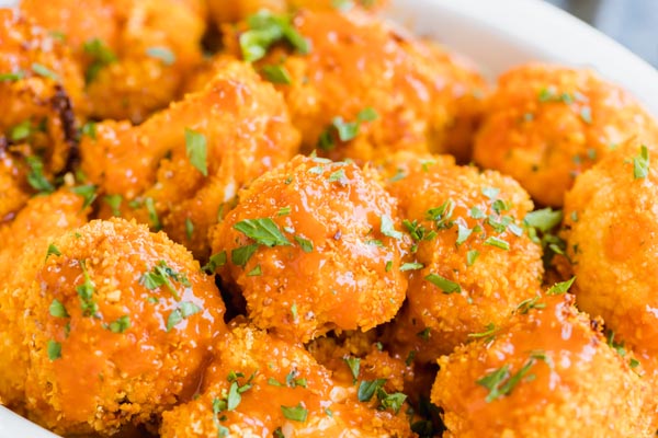 Saucy orange buffalo cauliflower topped with chopped parsley