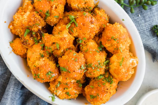 crunchy cauliflower bites with buffalo sauce and parsley