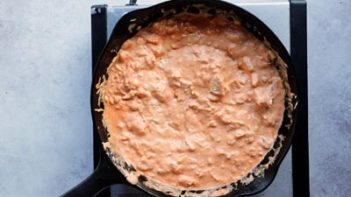 creamy buffalo chicken sauce in skillet on a burner