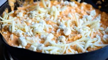 creamy buffalo dip with shredded cheese and blue cheese on top