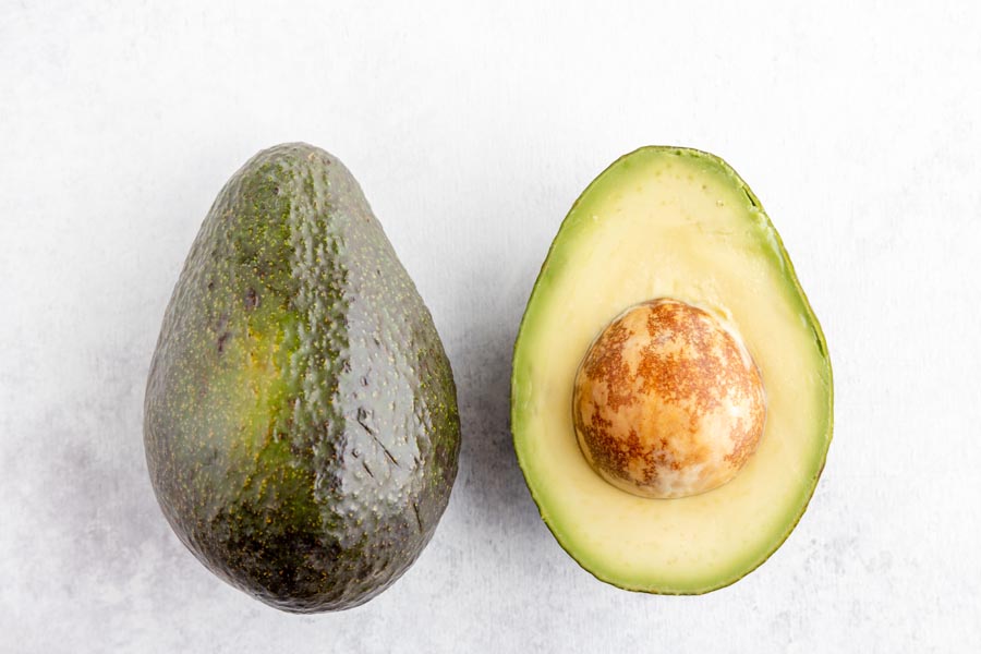a whole avocado on the left, a half avocado on the right