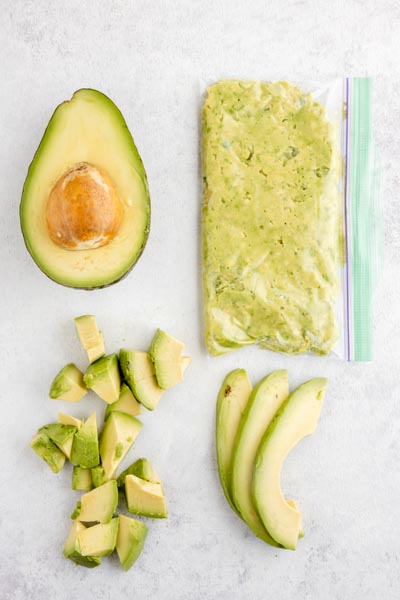 half an avocado next to a bag with mashed avocado with diced and sliced avocado below these