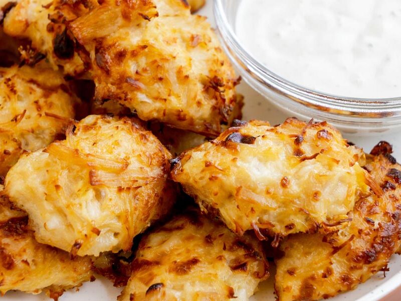 A close-up of crispy, cheesy canned chicken nuggets with a bowl of ranch dipping sauce.