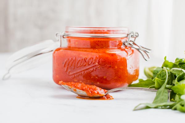 keto tomato sauce in a jar with a spoon on table