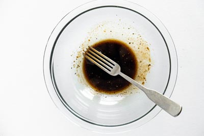 a glass bowl with a fork that had mixed up the balsamic dressing