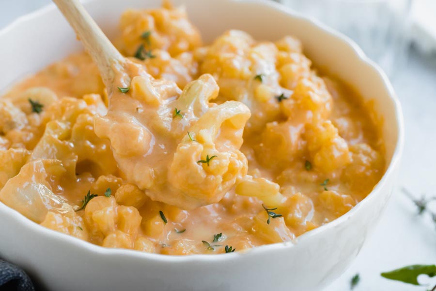 a wooden spoon holding low carb cauli mac and cheese