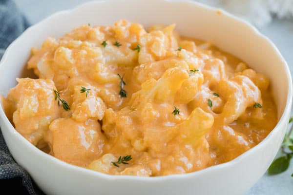 a white bowl with orange color mac and cheese in it