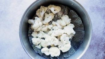 raw cauliflower in a steaming basket