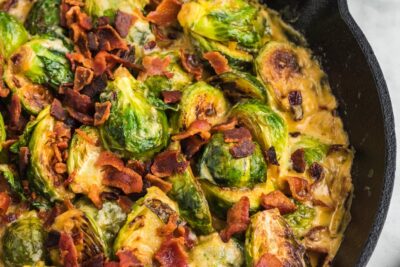 Crumbled bacon on top of a cheesy brussel sprouts casserole.