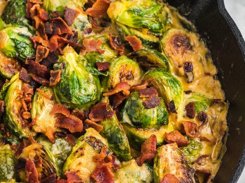 Crumbled bacon on top of a cheesy brussel sprouts casserole.