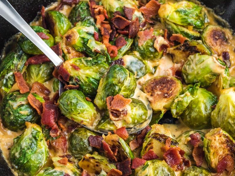 A spoon holding creamy brussels sprouts side dish.