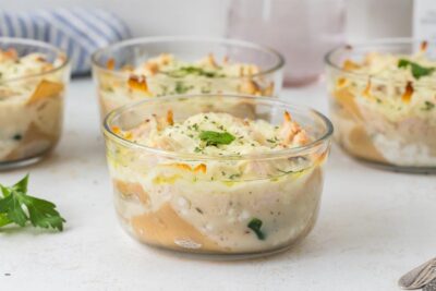 Individual bowls of chicken Alfredo lasagna layered with creamy sauce, cheese, and noodles.