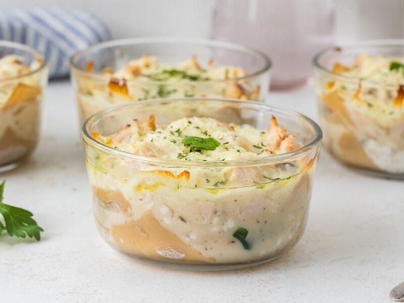 Individual bowls of chicken Alfredo lasagna layered with creamy sauce, cheese, and noodles.