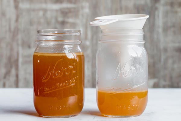 chicken bone broth funneled into a mason jar