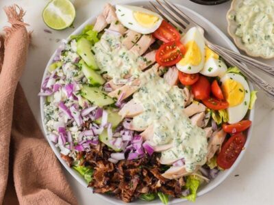 Chicken Cobb salad with bacon, eggs, cucumber, tomatoes, red onion, blue cheese and herb dressing.