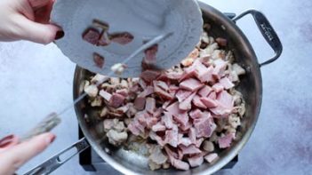 adding diced ham to a skillet with cooked chicken
