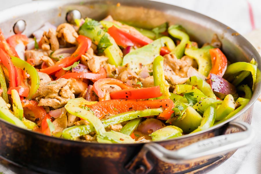 Cooked fajitas in a skillet.