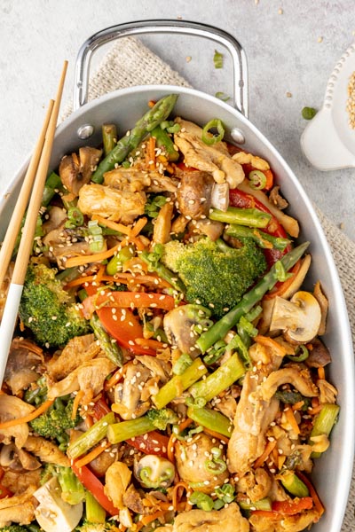 chicken and veggie stir fry skillet with chopsticks on the side