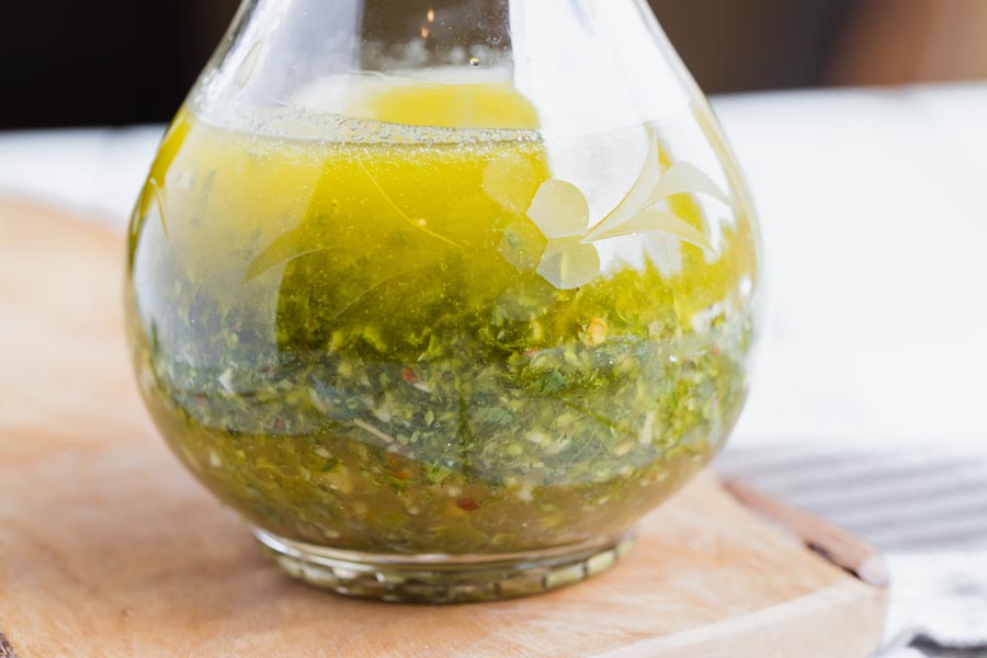 oil based herb dressing in a glass salad dressing bottle