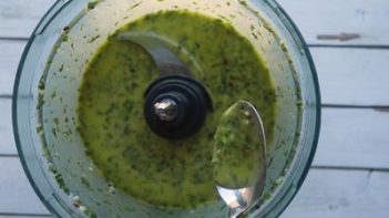 a spoonful of chimichurri sauce over a food processor
