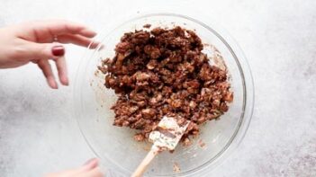 mixing granola mixture in a clear bowl