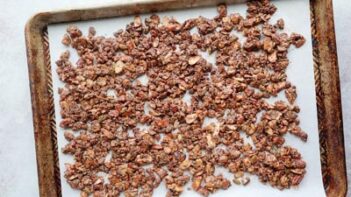 granola nut and seeds mixture spread on a parchment lined tray