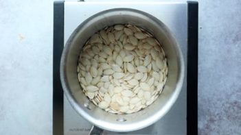 pumpkin seeds boiling in a sauce pan