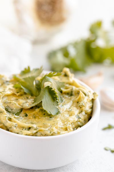 Creamy aioli filled with chopped cilantro leaves in a white bowl.