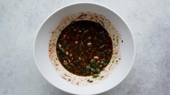 A white bowl with a marinade inside.