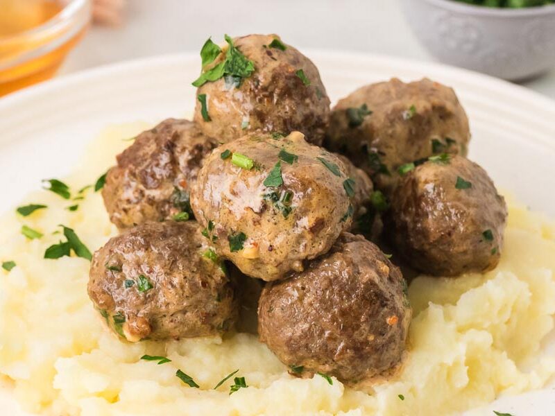 Juicy homemade cowboy butter meatballs piled over mashed cauliflower and sprinkled with fresh parsley.