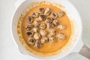 Browned meatballs simmering in a skillet of creamy cowboy butter sauce until fully coated and ready to serve.