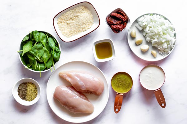 ingredients for a Tuscan chicken dinner on a white counter