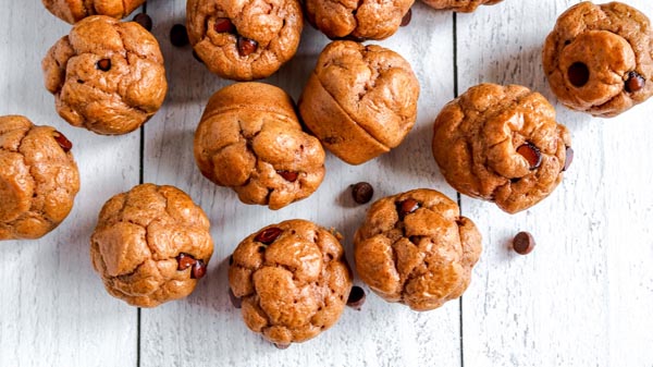 a bunch of mini chocolate chip muffins on a white wooden board