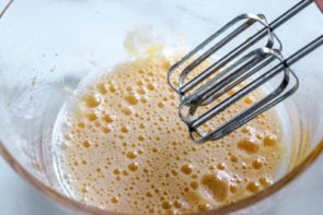 frothy eggs in a mixing bowl with egg beaters