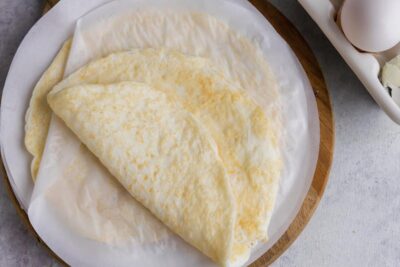 An egg white wrap folded on top of parchment paper.