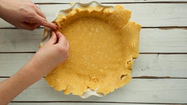 pinch fluted edges around a pie crust