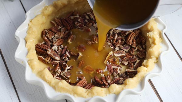 pouring pie filling into a pie