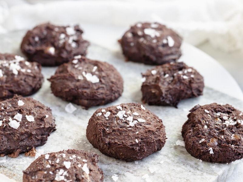 chocolate cookies on a marble circular board topped with flaked salt