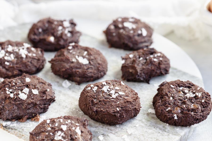chocolate cookies on a marble circular board topped with flaked salt