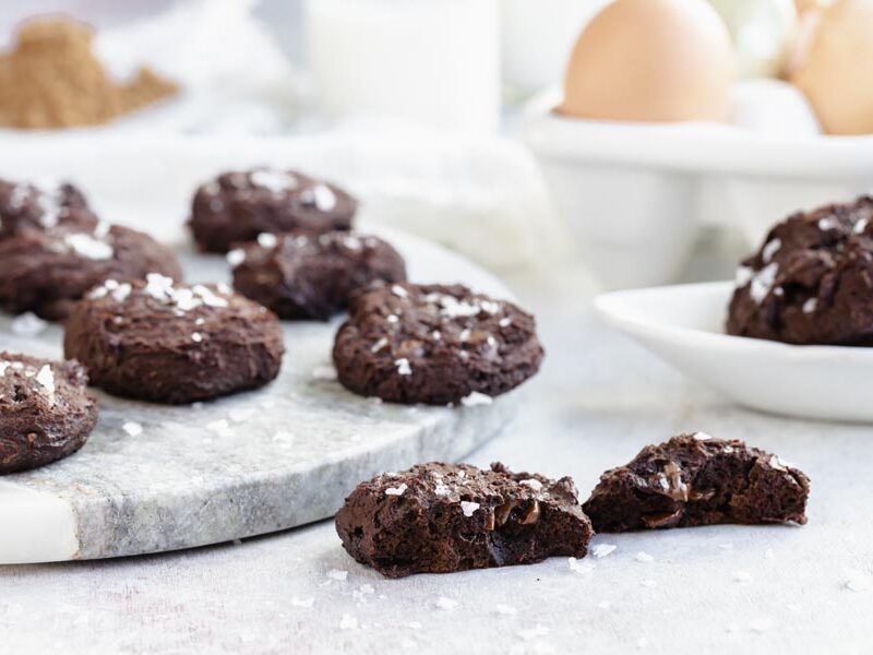a cookie split in half to shoe the melted chocolate chips with more cookies in the background