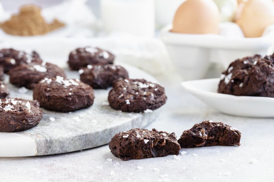 a cookie split in half to shoe the melted chocolate chips with more cookies in the background