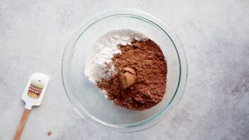powdered sweetener and cocoa powder in a glass bowl with a spatula to the left
