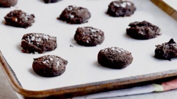 chocolate cookies lined on a parchment lined baking tray