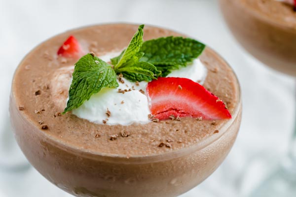 frozen hot chocolate topped with strawberries, whipped cream and mint