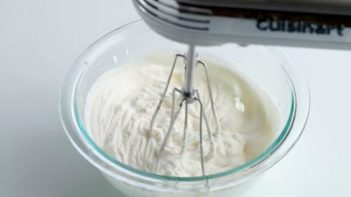 making whipped cream in a bowl with an electric mixer